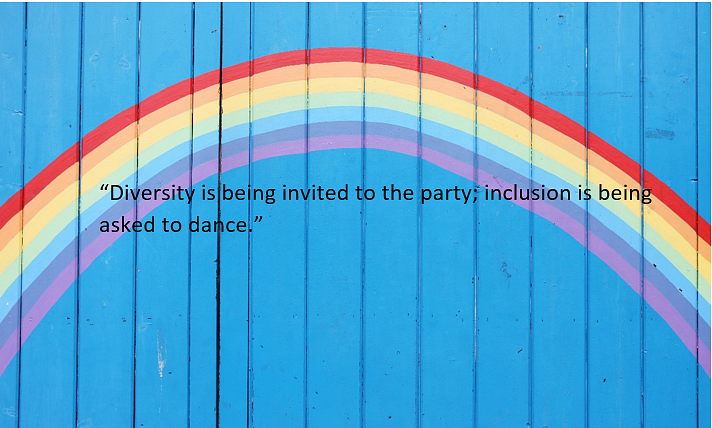 Blue fence with a rainbow painted on it; text reads "Diversity is being invited to the party; inclusion is being asked to dance"