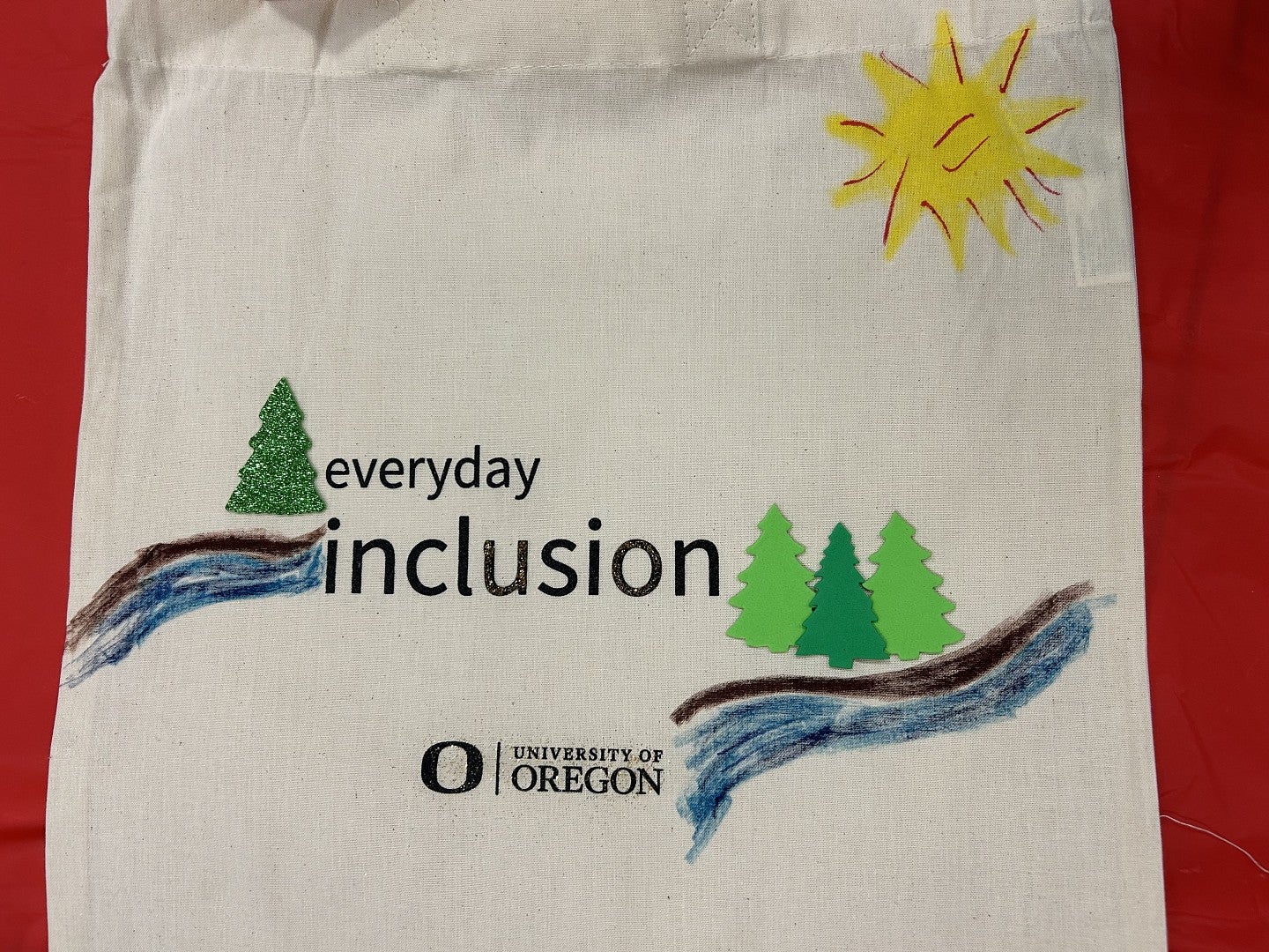 Everyday Inclusion tote bag with trees, river, and the sun