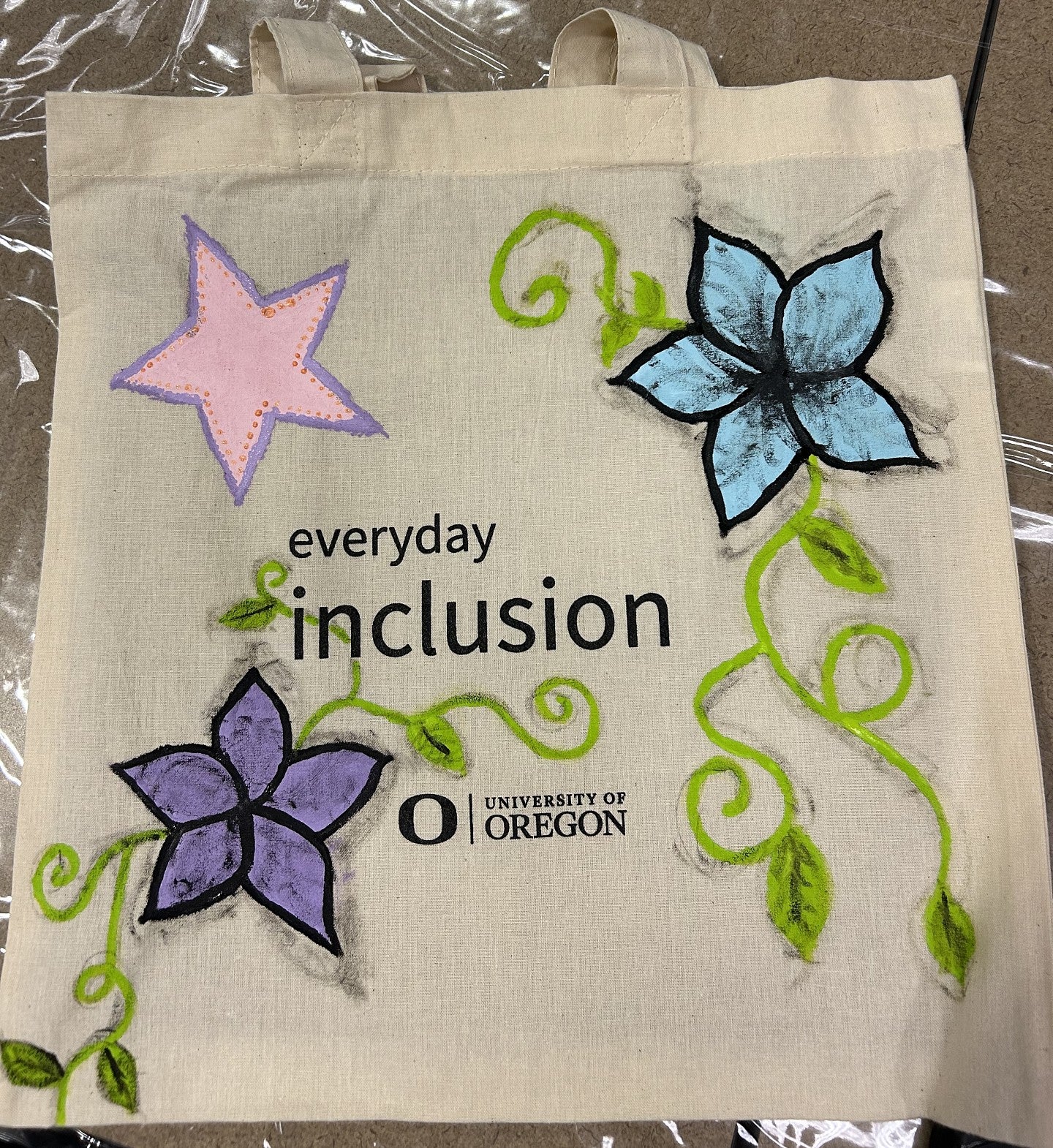 Everyday Inclusion tote bag with a star, and flowers on vines, with leaves