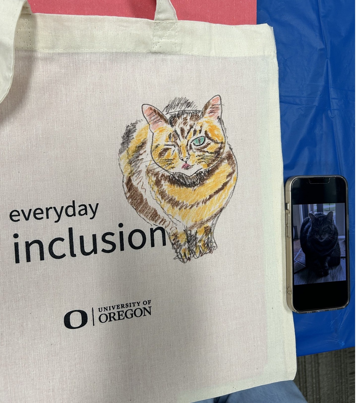 Everyday inclusion bag with design of a cat and picture of the cat on a phone