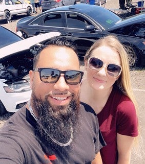 Eric and his wife at a car show--cars with bonnets open behind them